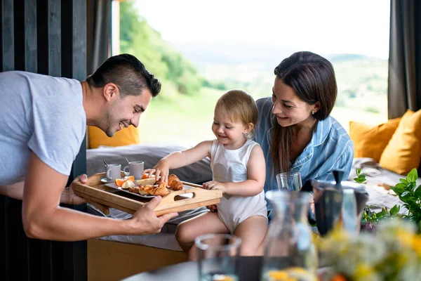 Junges Paar mit kleiner Tochter drinnen, Wochenende im Containerhaus auf dem Land. — Stockfoto