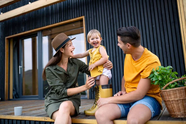 Young family with small daughter outdoors, weekend away in container house in countryside. — Stock Photo, Image