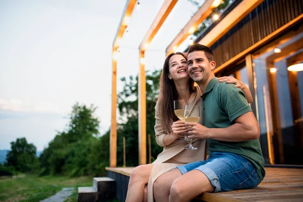 Pareja joven con vino al aire libre, fin de semana en casa contenedor en el campo. —  Fotos de Stock