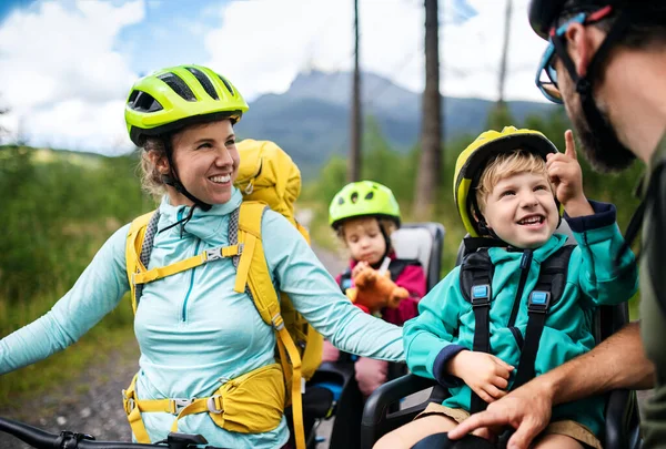 Rodina s malými dětmi cyklistika venku v letní přírodě. — Stock fotografie