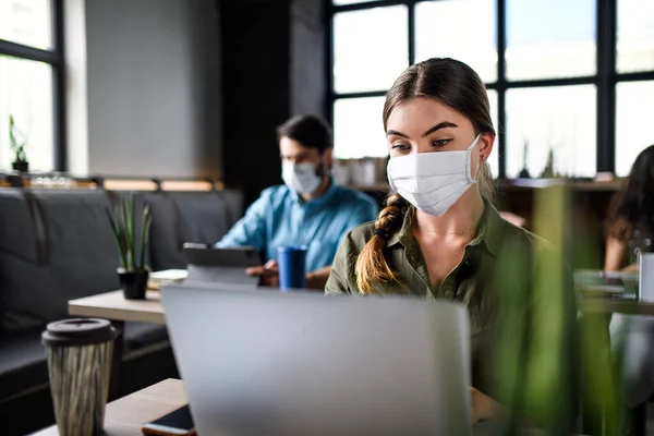 Gente de negocios con máscaras faciales en el interior de la oficina, de vuelta al trabajo después del bloqueo del coronavirus. —  Fotos de Stock