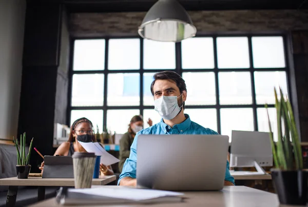 Business people with face masks indoors in office, back to work after coronavirus lockdown. — Stock Photo, Image