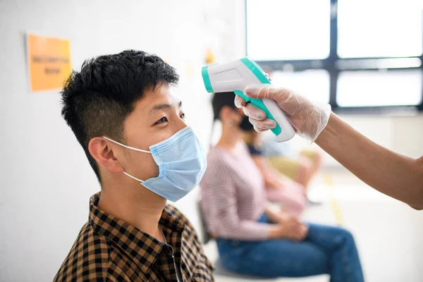 People with face masks, coronavirus, covid-19, measuring temperature and vaccination concept.