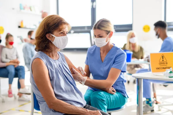 Vrouw met gezichtsmasker krijgt gevaccineerd, coronavirus, covid-19 en vaccinatie concept. — Stockfoto