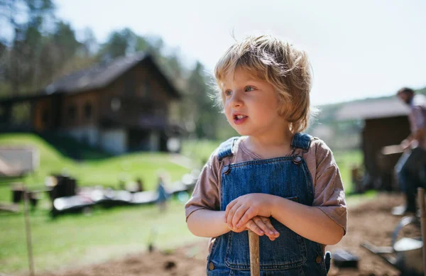 Kleine jongen die buiten in de tuin werkt, duurzaam lifestyle concept. — Stockfoto