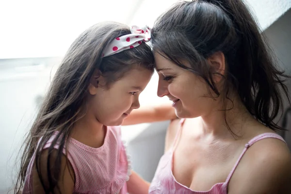 Mother and small daughter indoors at home, hugging. — Stock Photo, Image