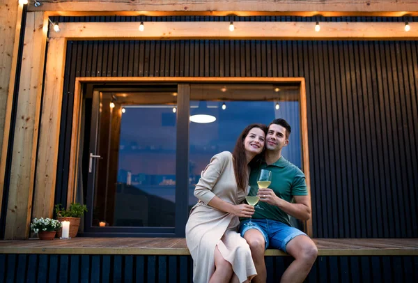 Young couple with wine outdoors, weekend away in container house in countryside. — Stock Photo, Image