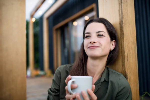 Young woman with coffee outdoors, weekend away in container house in countryside. — Stock Photo, Image