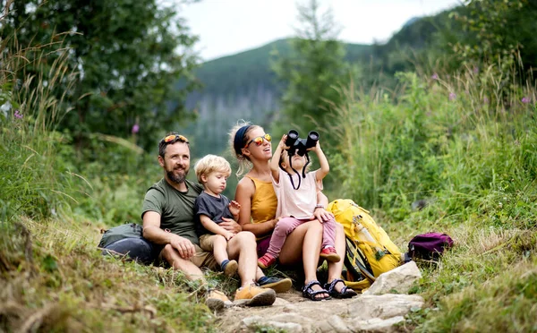 Rodzina z małymi dziećmi piesze wycieczki na świeżym powietrzu w lecie charakter, siedzi i odpoczywa. — Zdjęcie stockowe