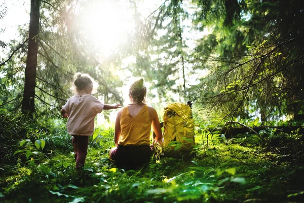 Bakifrån av mor med liten dotter utomhus i sommar natur, vila. — Stockfoto