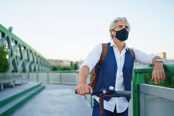 Пожилой человек пригородный с маской для лица и электрическим скутером на открытом воздухе в городе, коронавирус концепции. — стоковое фото