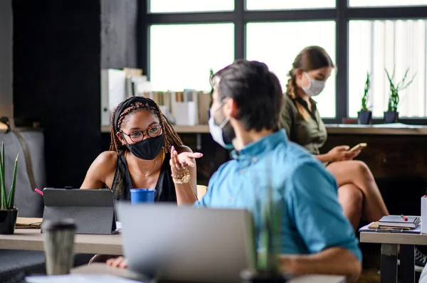 Business people with face masks indoors in office, back to work after coronavirus lockdown. — Stock Photo, Image