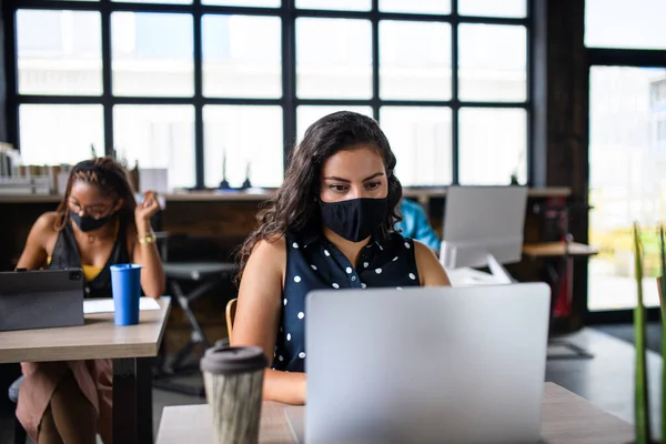 Mulher de negócios com máscara facial dentro de casa no escritório, de volta ao trabalho após o bloqueio do coronavírus. — Fotografia de Stock