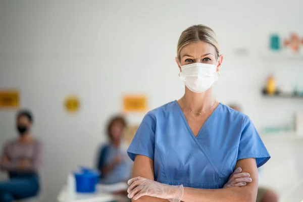 Portret van een arts met gezichtsmasker op zoek naar camera, coronavirus, covid-19 en vaccinatie concept. — Stockfoto