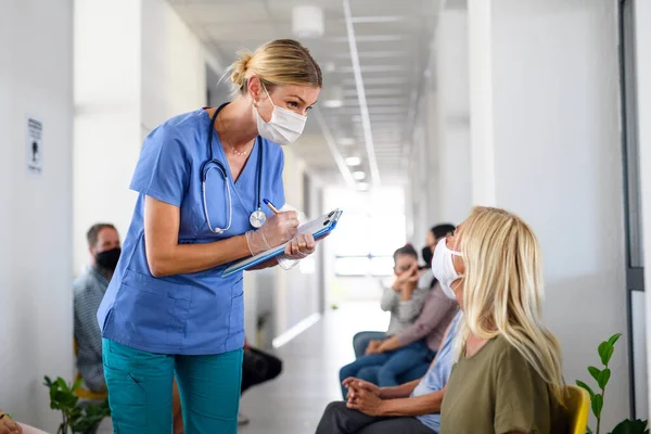 Porträt einer Krankenschwester mit Mundschutz im Gespräch mit Patienten, Coronavirus, Covid-19 und Impfkonzept. — Stockfoto