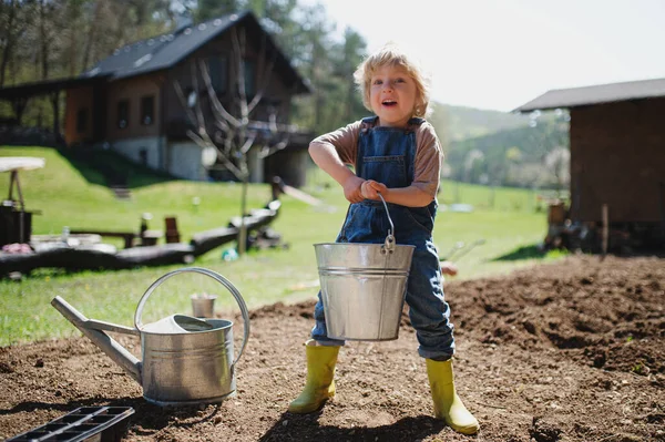 Маленький мальчик работает на открытом воздухе в саду, концепция устойчивого образа жизни. — стоковое фото
