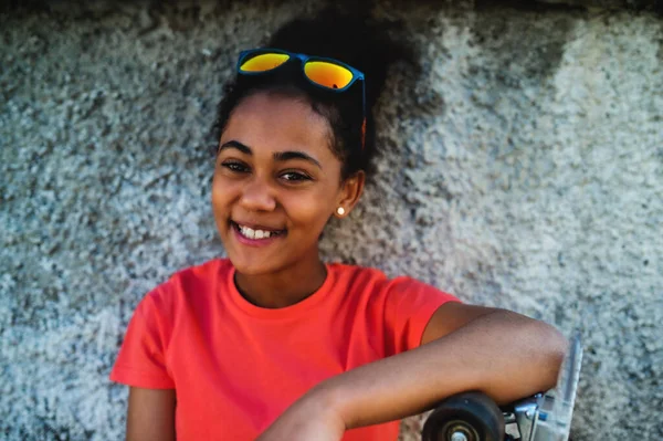 Young teenager girl sitting outdoors in city, leaning on concrete wall. — Stock Photo, Image