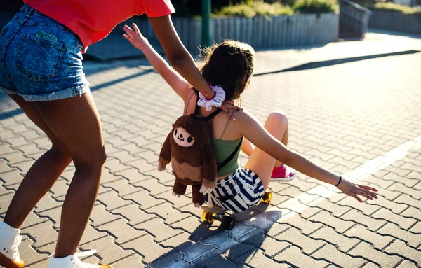 Gadis remaja berteman dengan skateboard di luar kota, bersenang-senang. — Stok Foto