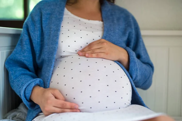 Unrecognizable pregnant woman sitting indoors at home. — Stock Photo, Image