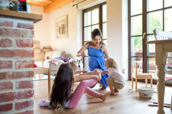 Mulher grávida com crianças pequenas dentro de casa, brincando. — Fotografia de Stock