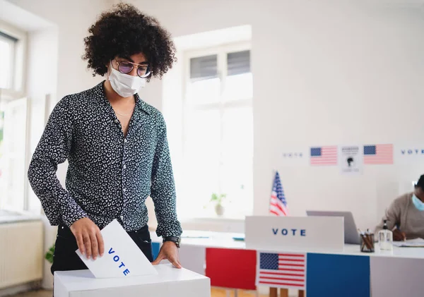 Joven poniendo su voto en las urnas, en las elecciones de EE.UU. y en el coronavirus. — Foto de Stock