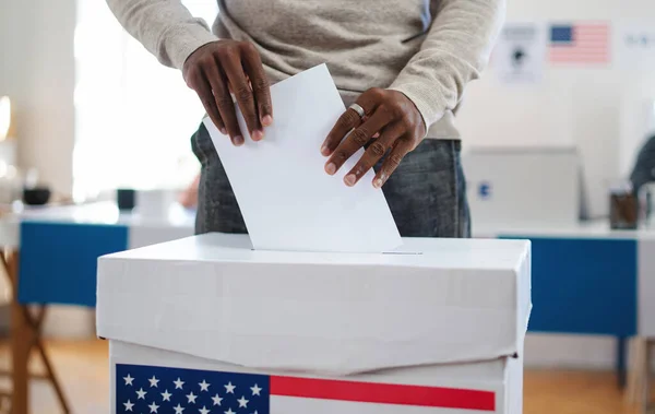 Hombre afroamericano irreconocible poniendo su voto en las urnas, en las elecciones de EE.UU. y en el coronavirus. — Foto de Stock