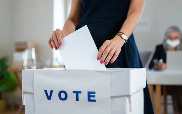 Mulher irreconhecível colocando seu voto nas urnas, EUA e eleições para coronavírus. — Fotografia de Stock
