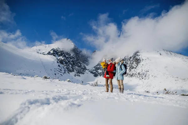 Far och mor med liten son i vinternaturen, stående i snön. — Stockfoto