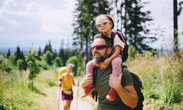 Rodina s malými dětmi pěší turistika venku v letní přírodě. — Stock fotografie