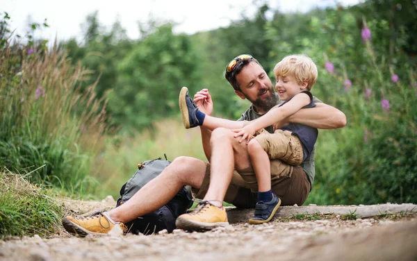 Father with small son hiking outdoors in summer nature, resting. — Stock Photo, Image