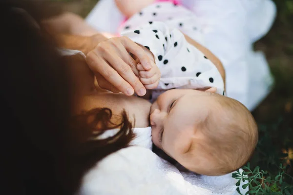 Visão superior da mulher amamentando bebê menina ao ar livre no quintal. — Fotografia de Stock