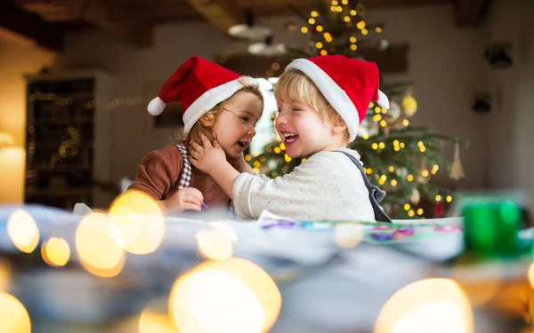 Porträt eines kleinen Mädchens und eines Jungen, die zu Weihnachten zu Hause sind und Spaß haben. — Stockfoto