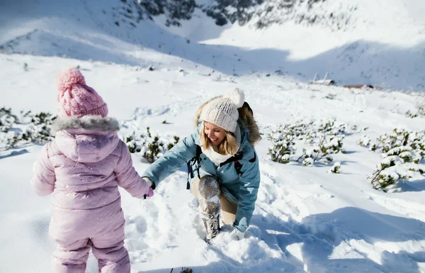 Mãe com pequena filha andando na neve no inverno natureza, conceito de férias. — Fotografia de Stock