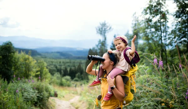 Madre con figlioletta che cammina all'aperto nella natura estiva, usando il binocolo. — Foto Stock