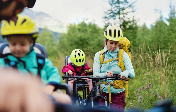 Famiglia con bambini piccoli in bicicletta all'aperto nella natura estiva, riposo. — Foto Stock