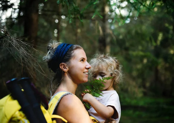 Side view of mother with small daughter outdoors in summer nature, resting. — Stock Photo, Image