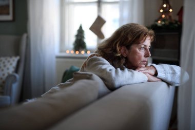 Noel 'de evde, kanepede oturan yalnız yaşlı kadın, yalnızlık kavramı..