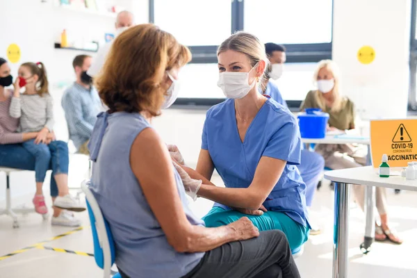 Vrouw met gezichtsmasker krijgt gevaccineerd, coronavirus, covid-19 en vaccinatie concept. — Stockfoto