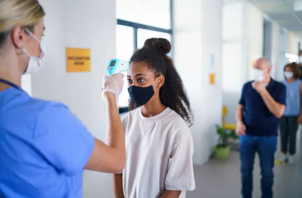 People with face masks, coronavirus, covid-19, measuring temperature and vaccination concept. — Stock Photo, Image