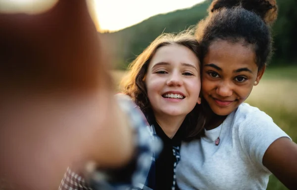 Pandangan depan gadis-gadis remaja teman luar ruangan di alam, mengambil selfie. — Stok Foto