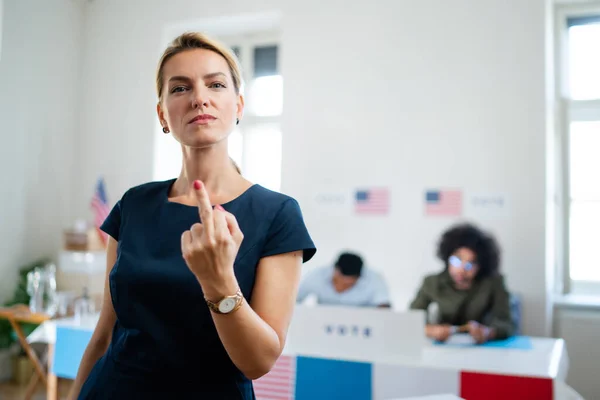 有信心的女性选民在投票站表现出中指的画像，美国选举概念. — 图库照片