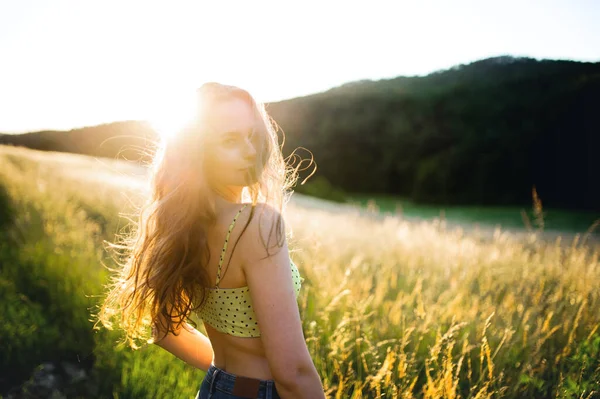 Portret van jonge tiener meisje buiten in de natuur bij zonsondergang. — Stockfoto