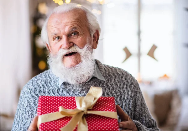 Vorderansicht eines glücklichen Seniors mit Geschenkbox zu Weihnachten zu Hause. — Stockfoto