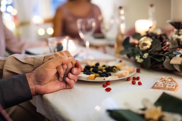 Közelkép a kezét tartja össze az asztalnál karácsonykor, imádkozás koncepció. — Stock Fotó