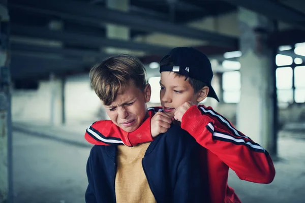 Teenage boy attacked by thug in abandoned building, gang violence and bullying concept. — Stock fotografie