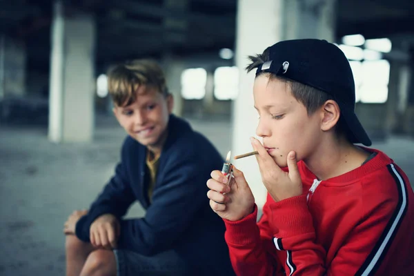 Group of teenagers boys indoors in abandoned building, smoking cigarettes. — Stock Photo, Image