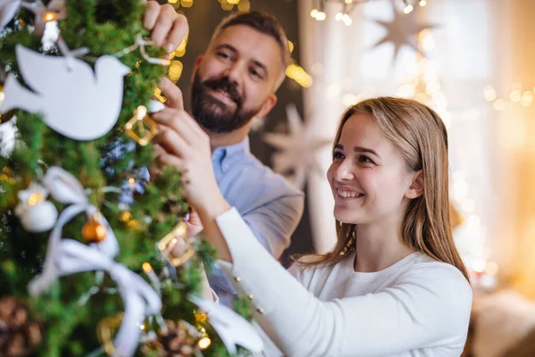 Casal feliz dentro de casa em casa no Natal, árvore de decoração. — Fotografia de Stock