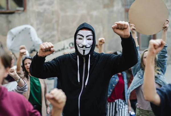 Группа людей-активистов в маске протестует на улицах, забастовке и демонстрации. — стоковое фото