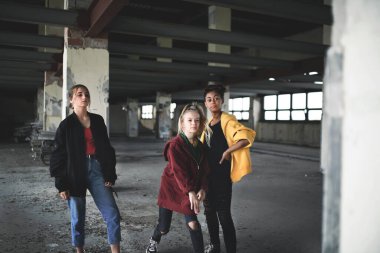 Terk edilmiş binada genç kız eşkıyalara saldırı, çete şiddeti ve zorbalık kavramı.