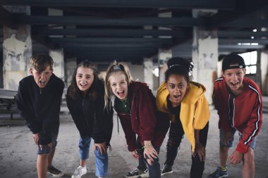 Terk edilmiş bir binada kameraya bakan bir grup genç çete..